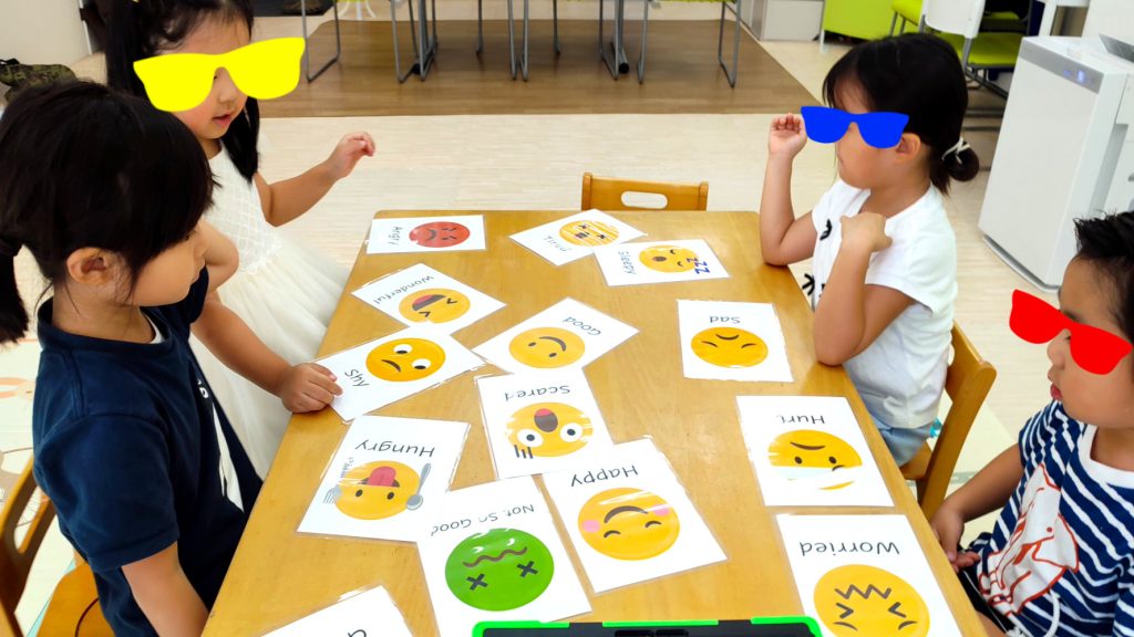 様々な表情のカードを使って、「Happy」「Sad」「Worried」などの感情を英語で学んでいます。 自分の気持ちを適切に表現する力は、国際的なコミュニケーションにおいて非常に重要です。MiQ English Schoolでは、語彙力だけでなく、心の知能（EQ）も英語で育むことを大切にしています。 感情豊かに英語を話せるお子さんを目指し、MiQ English Schoolで一緒に学びましょう！
