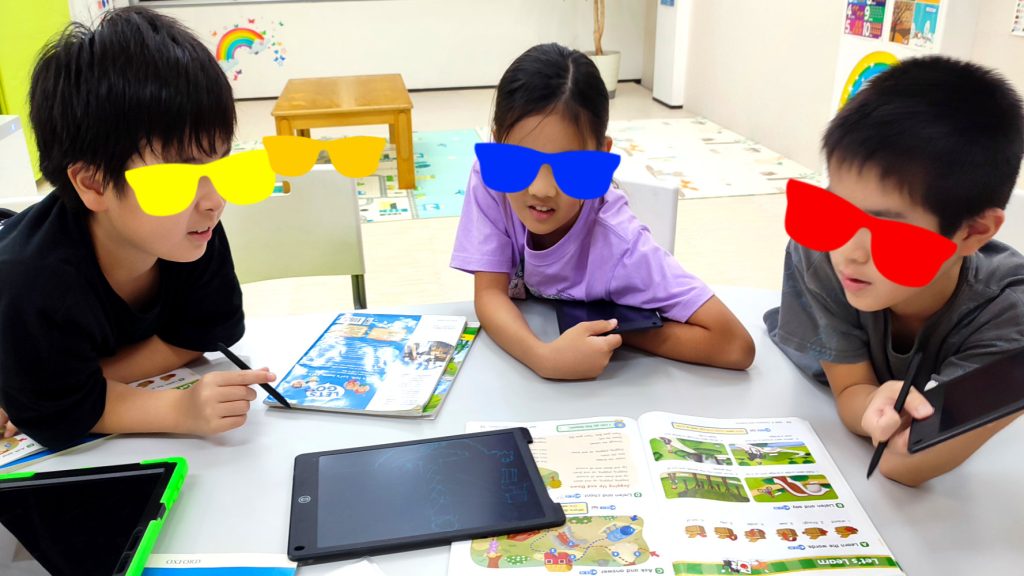 【MiQ English Schoolでのアートと会話】 生徒さんたちが、自分が描いた絵について話し合っている様子です。 絵を描くことは、言葉だけでは伝えにくい思考やイメージを表現する良い手段です。MiQ English Schoolでは、この創造的な活動を通して、表現力を高めるための英語での対話を重視しています。